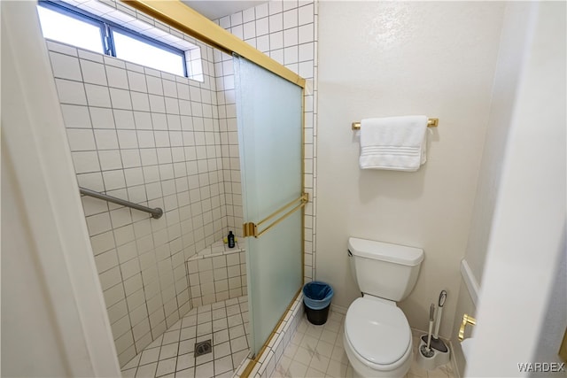 bathroom featuring a stall shower, baseboards, toilet, and tile patterned floors