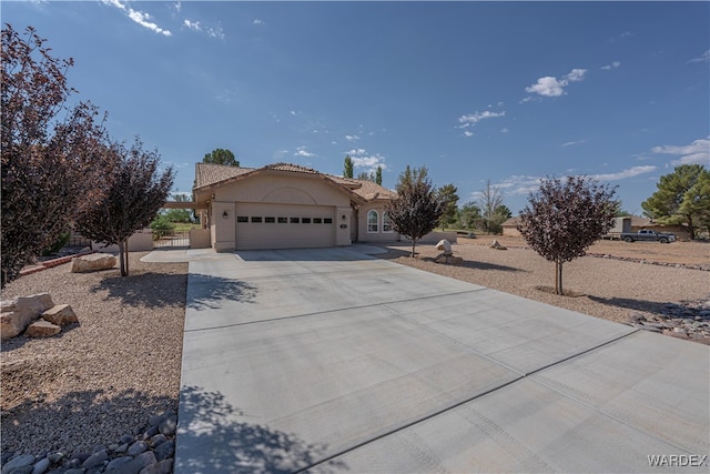 view of front of property featuring a garage, concrete driveway, and stucco siding