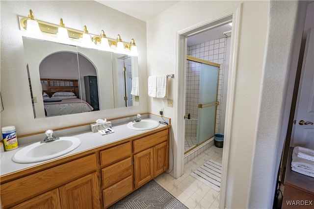 bathroom with a stall shower, a sink, and connected bathroom