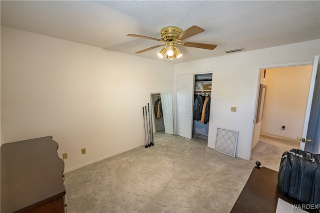 bedroom featuring visible vents, light colored carpet, ceiling fan, a textured ceiling, and a closet