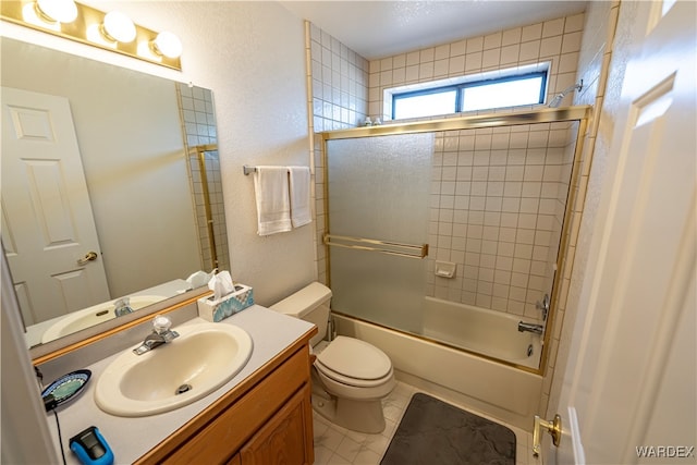 full bathroom with a textured wall, toilet, enclosed tub / shower combo, vanity, and tile patterned floors