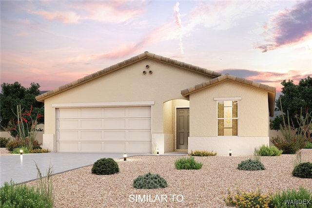 view of front of property featuring stucco siding, driveway, an attached garage, and a tile roof