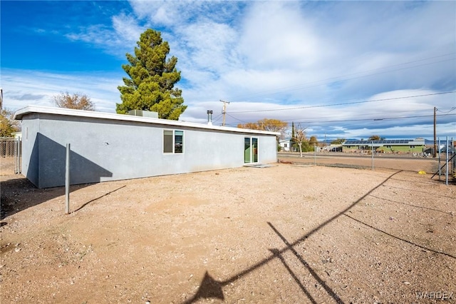 back of property with fence and stucco siding