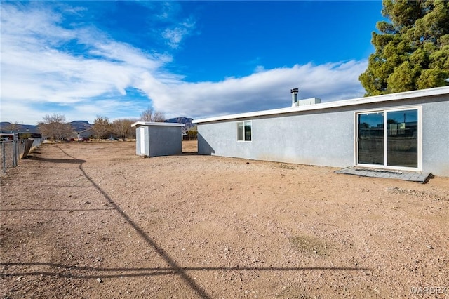 back of property featuring fence and stucco siding