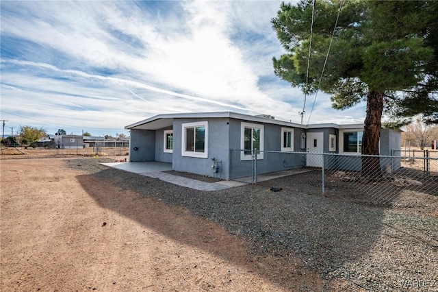 view of front of house featuring a patio area, a fenced backyard, and stucco siding