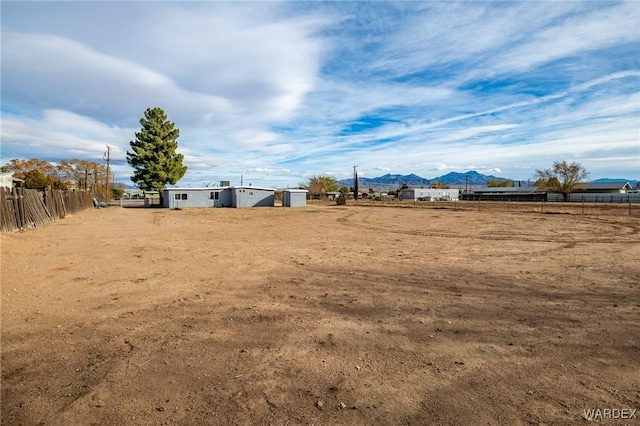 view of yard featuring fence and a mountain view