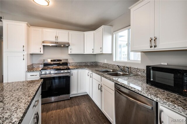 kitchen featuring under cabinet range hood, a sink, white cabinets, appliances with stainless steel finishes, and dark wood finished floors