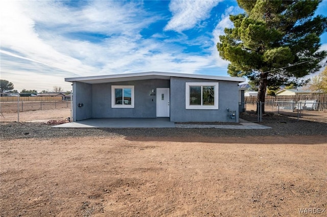 view of front facade featuring a patio area, fence, and stucco siding