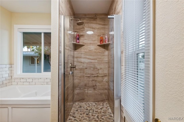 full bathroom featuring a garden tub and a shower stall