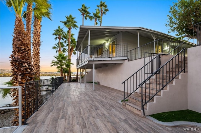 view of front of home with a patio area, stairs, and stucco siding