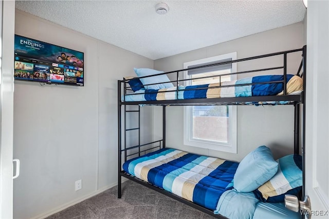 bedroom with carpet floors, baseboards, and a textured ceiling