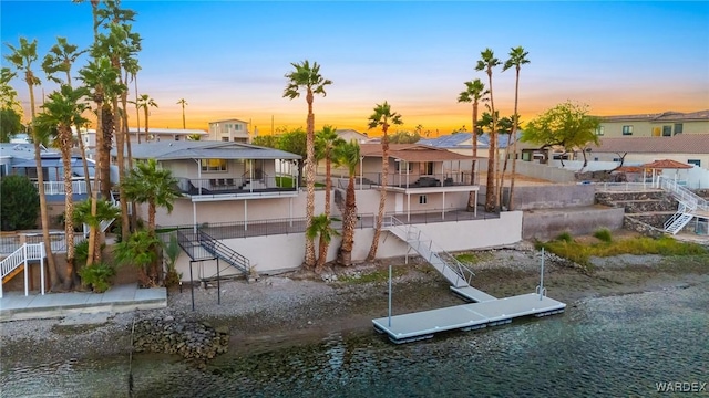 dock area featuring stairway, a water view, and a residential view