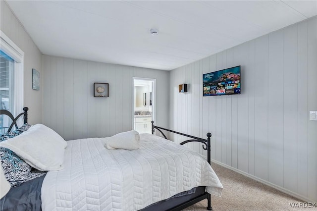 bedroom with carpet floors, ensuite bath, and baseboards