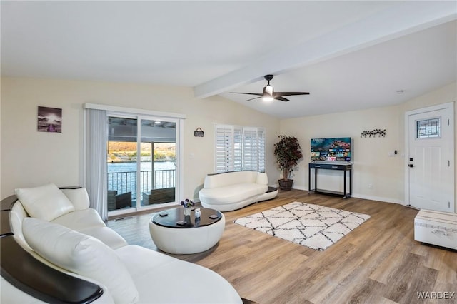 living area with a ceiling fan, vaulted ceiling with beams, baseboards, and wood finished floors