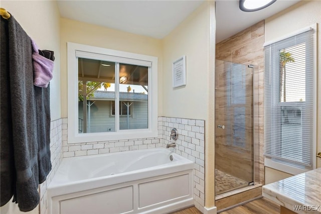 bathroom with a shower stall and a bath