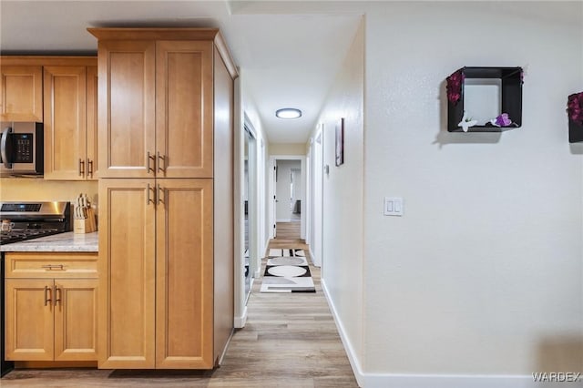 hall with light wood finished floors and baseboards