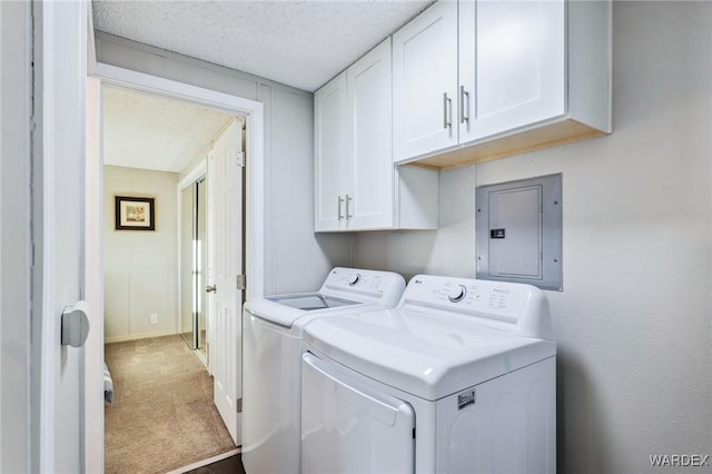 washroom featuring cabinet space, electric panel, a textured ceiling, carpet flooring, and washing machine and dryer