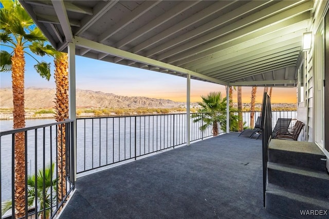 patio terrace at dusk featuring a mountain view and a balcony