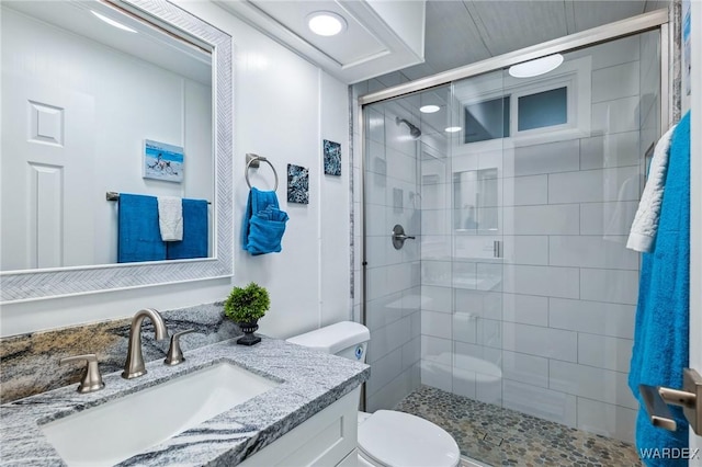 bathroom with toilet, a shower stall, and vanity