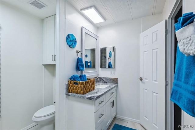 bathroom with toilet, baseboards, visible vents, and vanity