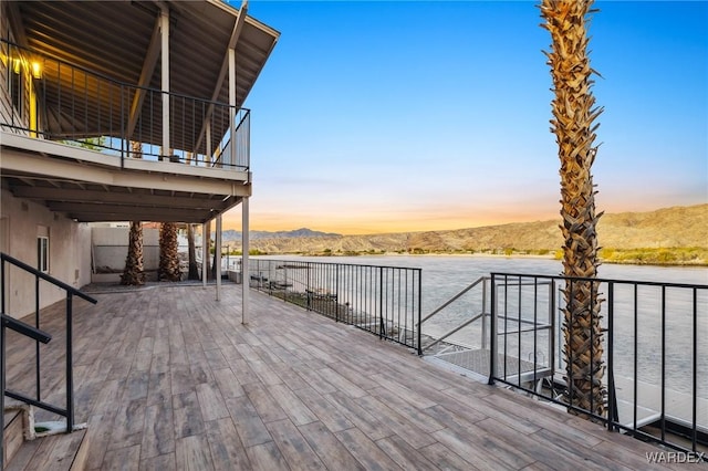 wooden deck with a water and mountain view