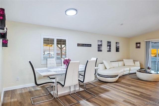 dining room featuring plenty of natural light, baseboards, and wood finished floors