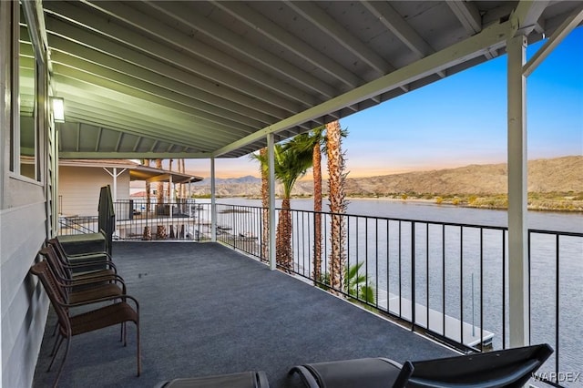 view of patio / terrace with a balcony and a water and mountain view