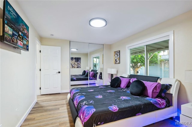 bedroom featuring a closet, wood finished floors, and baseboards