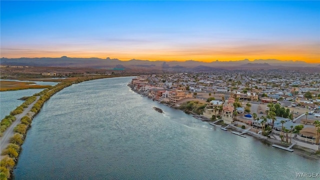 aerial view at dusk featuring a residential view and a water and mountain view