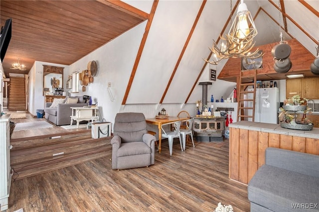 living area with wood ceiling, vaulted ceiling, wood finished floors, and a notable chandelier