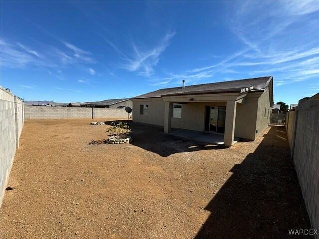 back of house with a patio area, a fenced backyard, and stucco siding