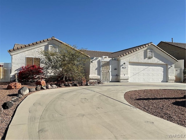 ranch-style house with a garage, concrete driveway, a tiled roof, and stucco siding