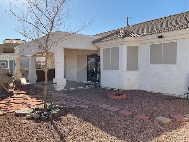 entrance to property featuring a tile roof and stucco siding