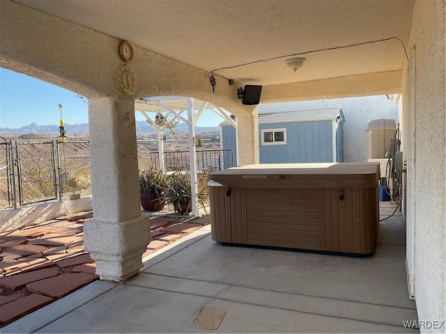 view of patio / terrace with a mountain view and a hot tub