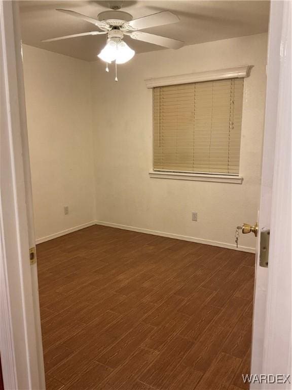 unfurnished room with dark wood-style floors, ceiling fan, and baseboards