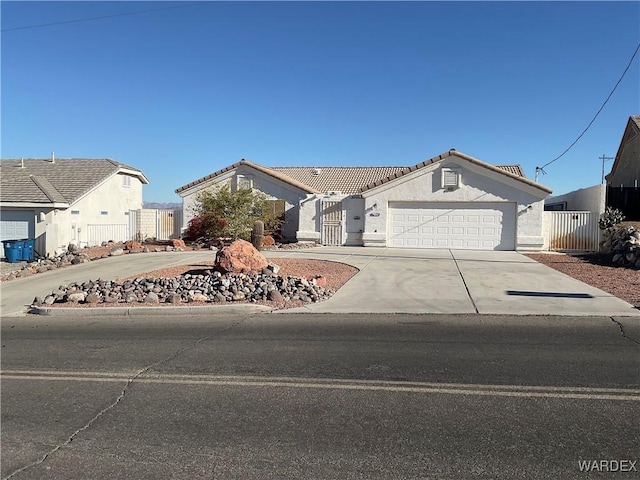 view of front of house with a garage, fence, concrete driveway, a tiled roof, and stucco siding