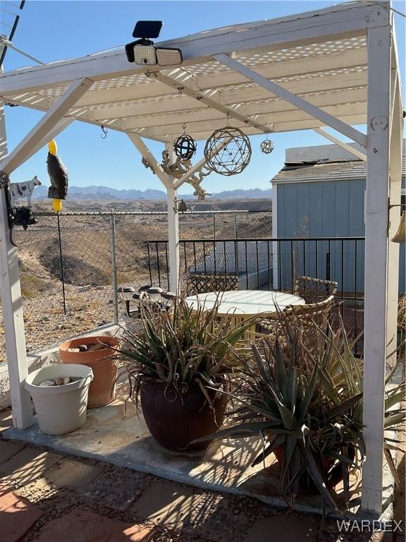 view of patio featuring a mountain view, fence, and a pergola