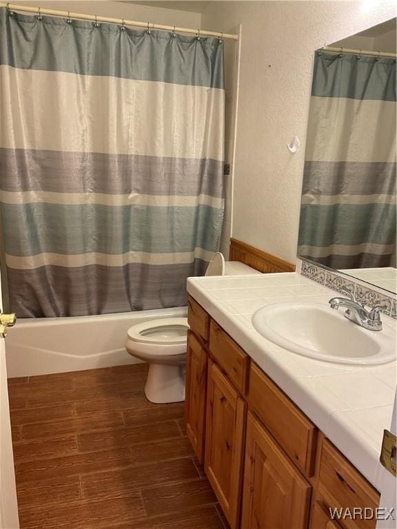 full bathroom featuring a textured wall, toilet, shower / tub combo, wood finished floors, and vanity