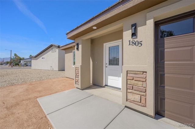 doorway to property featuring a patio and stucco siding