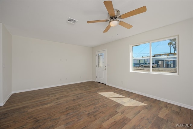 empty room featuring a ceiling fan, wood finished floors, visible vents, and baseboards