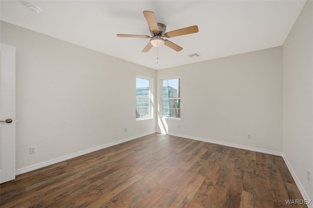 unfurnished room featuring a ceiling fan, dark wood finished floors, visible vents, and baseboards