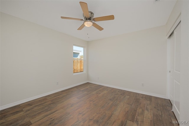 unfurnished bedroom featuring hardwood / wood-style flooring, ceiling fan, baseboards, and a closet