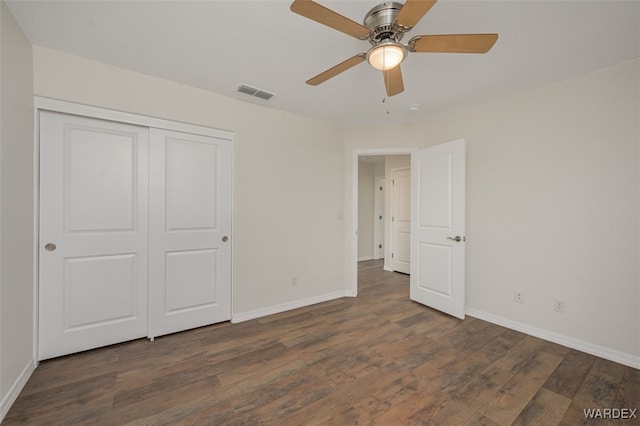 unfurnished bedroom with a closet, wood finished floors, visible vents, and baseboards