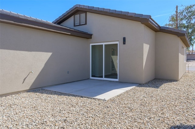 back of property featuring a patio area and stucco siding