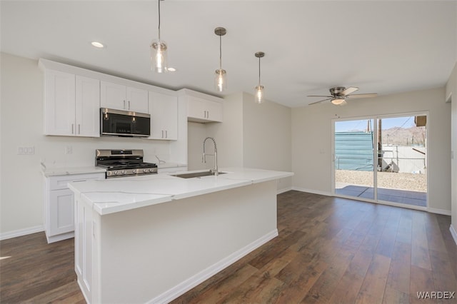 kitchen featuring dark wood-style flooring, appliances with stainless steel finishes, white cabinets, and a sink