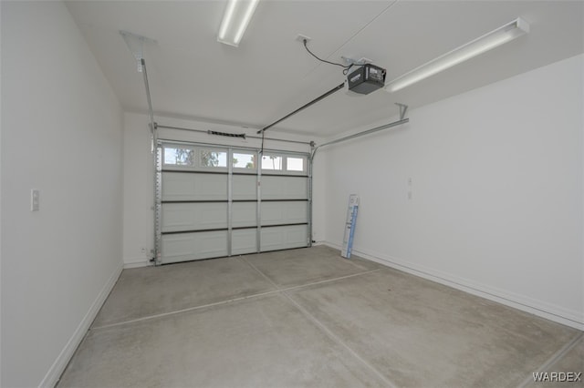 garage featuring a garage door opener and baseboards