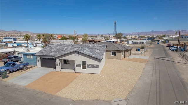 view of front of property featuring stucco siding, an attached garage, a mountain view, a residential view, and driveway