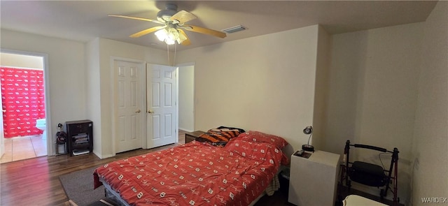 bedroom with ceiling fan, wood finished floors, and visible vents