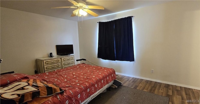 bedroom with a ceiling fan, baseboards, and wood finished floors