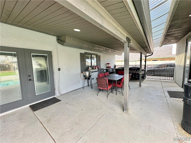 view of patio featuring outdoor dining space, fence, and french doors